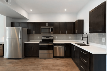 A kitchen with black cabinets and stainless steel appliances